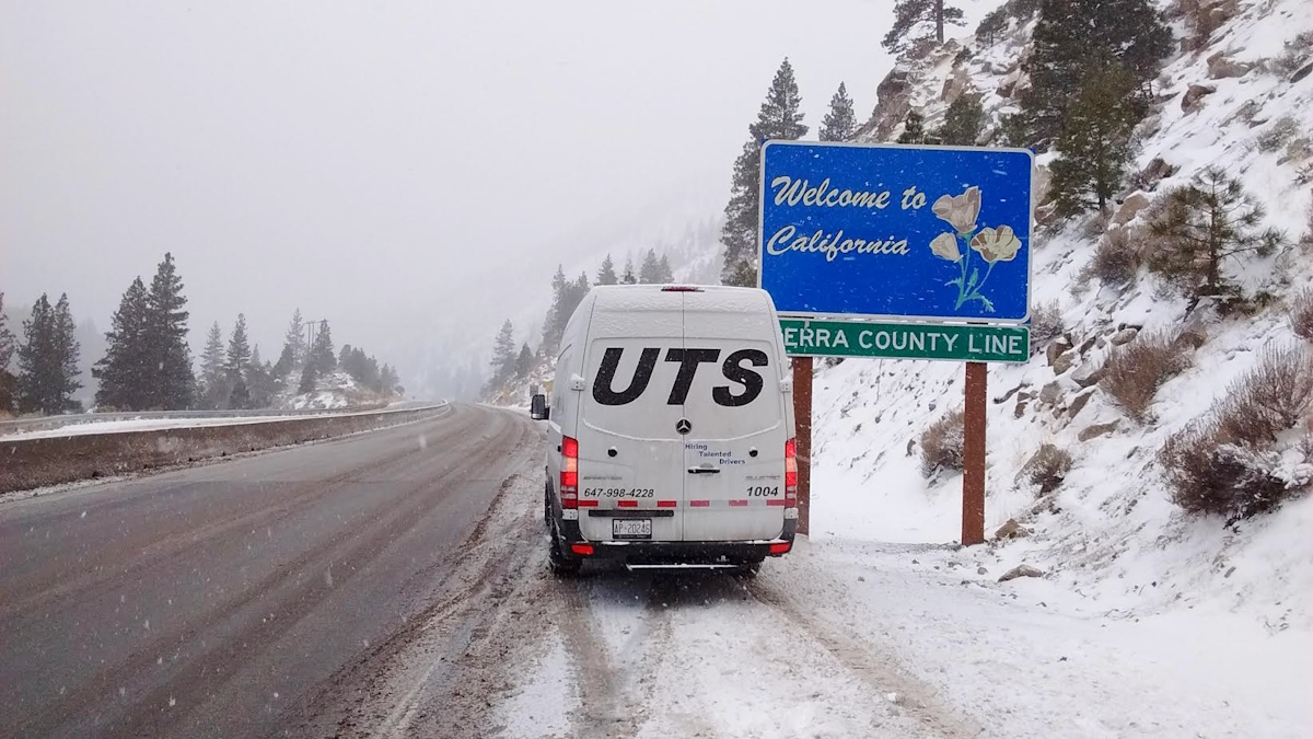 UTS vehicle beside a Welcome to California sign